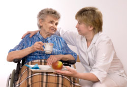 caregiver serving a foods to an old woman